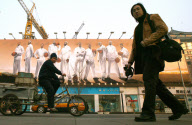 PEOPLE WALK PAST A GIANT NIKE BILLBOARD