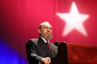 Fidel Castro talks in front of giant Cuba flag