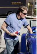 Singer JOHNNY HALLYDAY running around with a unfinished hair cut