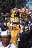BALINESE CARRYING  TOWERS OF VOTIVE GIFTS,PELIATAN VILLAGE, BALI, INDONESIA