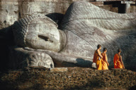 MONKS IN FRONT OF LYING BUDDHA STATUE, POLONNARUWA, SRI LANKA
