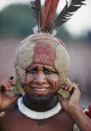 YOUNG DANCER WITH MODERN HEADDRESS: FOOTBALL AND FEATHERS, PREPARED FOR SUMMER FESTIVAL, XINGU INDIAN RESERVATION, BRAZIL