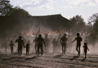 PEOPLE WITH FEATHER HAIRDRESS; PREPARING FOR DANCE AND SUMMER FESTIVAL AT DUSTY VILLAGE SQUARE, XINGU INDIAN RESERVATION, BRAZIL