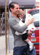 Muscular actor TOM CRUISE keeps little SURI smiling