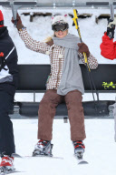 Paris Hilton and her dad ride a lift at Aspen. 