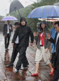 PRINCE FREDERIK and PRINCESS MARY standing in the rain at the Minh Mang Temple