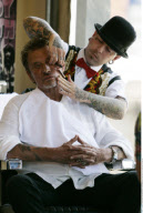 Singer JOHNNY HALLYDAY driving in his vintage roadster to a barber shop
