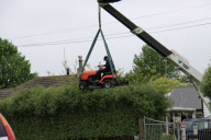 Gardener uses ride-on lawnmower to trim hedge, Cambridge, New Zealand - Nov 2009