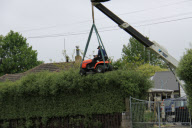 Gardener uses ride-on lawnmower to trim hedge, Cambridge, New Zealand - Nov 2009