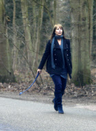 Linda de Mol with brown hair, walking her dogs