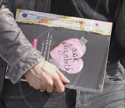 Elizabeth Berkley holds a "Ask Elizabeth" notebook