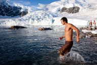 2009-02-28: Julian Bastida und zwei weitere Mitglieder des Expeditionsteams der MS Fram wagen vor der Gletscherkulisse bei Neko Harbour den "Polar Plunge" im antarktischen Meer. Das Wasser ist etwa 0¡C kalt.