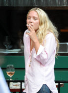 MARY KATE OLSEN WITH A MALE FRIEND SMOKING AND DRINKING OUTSIDE A RESTAURANT IN THE WEST VILLAGE  NEW YORK