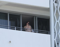 While on the balcony of his SoHo hotel room in Miami, Florida, the ever charismatic "Rock of Ages" star, Tom Cruise, gives the crowd below a little taste of the upcoming film as he gives a shirtless demonstration of his ability to 'rock out' with a microp