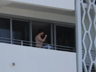 While on the balcony of his SoHo hotel room in Miami, Florida, the ever charismatic "Rock of Ages" star, Tom Cruise, gives the crowd below a little taste of the upcoming film as he gives a shirtless demonstration of his ability to 'rock out' with a microp