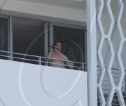 While on the balcony of his SoHo hotel room in Miami, Florida, the ever charismatic "Rock of Ages" star, Tom Cruise, gives the crowd below a little taste of the upcoming film as he gives a shirtless demonstration of his ability to 'rock out' with a microp