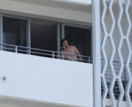 While on the balcony of his SoHo hotel room in Miami, Florida, the ever charismatic "Rock of Ages" star, Tom Cruise, gives the crowd below a little taste of the upcoming film as he gives a shirtless demonstration of his ability to 'rock out' with a microp