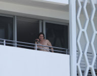 While on the balcony of his SoHo hotel room in Miami, Florida, the ever charismatic "Rock of Ages" star, Tom Cruise, gives the crowd below a little taste of the upcoming film as he gives a shirtless demonstration of his ability to 'rock out' with a microp