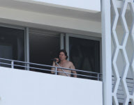 While on the balcony of his SoHo hotel room in Miami, Florida, the ever charismatic "Rock of Ages" star, Tom Cruise, gives the crowd below a little taste of the upcoming film as he gives a shirtless demonstration of his ability to 'rock out' with a microp