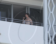 While on the balcony of his SoHo hotel room in Miami, Florida, the ever charismatic "Rock of Ages" star, Tom Cruise, gives the crowd below a little taste of the upcoming film as he gives a shirtless demonstration of his ability to 'rock out' with a microp