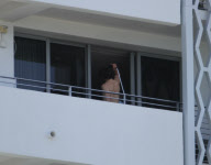While on the balcony of his SoHo hotel room in Miami, Florida, the ever charismatic "Rock of Ages" star, Tom Cruise, gives the crowd below a little taste of the upcoming film as he gives a shirtless demonstration of his ability to 'rock out' with a microp
