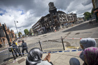 Aftermath of the Tottenham riots . local residents survey the damage including  a burnt out police van and Carpet Right Building gutted by arson . the building dates back to the 1930's . local MP David Lammy is also pictured visiting the scene with local 
