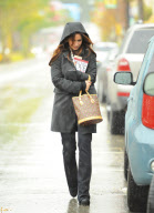 A Somber Looking Jennifer Love Hewitt Heads Out In The Rain Carrying The Book "Why Men Love Bitches"
