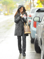 A Somber Looking Jennifer Love Hewitt Heads Out In The Rain Carrying The Book "Why Men Love Bitches"