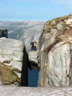 Hikers stand on Kjeragbolten boulder wedged 1,000m up between two cliff faces, Kjerag Mountains, Norway - 2003