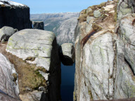 Hikers stand on Kjeragbolten boulder wedged 1,000m up between two cliff faces, Kjerag Mountains, Norway - 2003