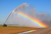 Water truck spraying field produces a rainbow, Florida, America - 2011