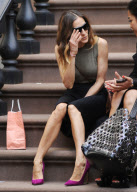 Actress Sarah Jessica Parker sitting on the stairs having a chat with a friend
