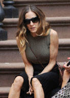 Actress Sarah Jessica Parker sitting on the stairs having a chat with a friend
