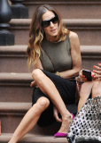 Actress Sarah Jessica Parker sitting on the stairs having a chat with a friend

