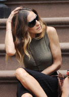 Actress Sarah Jessica Parker sitting on the stairs having a chat with a friend
