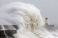 Gewaltige Brecher schlagen gegen den Leuchtturm von Porthcawl an der Küste von South Wales