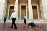 Elderly beggar woman crawling on pavement outside the Bank of Greece, Athens, Greece - 13 Jun 2012
