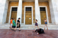 Elderly beggar woman crawling on pavement outside the Bank of Greece, Athens, Greece - 13 Jun 2012