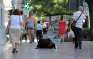 Elderly beggar woman crawling on pavement outside the Bank of Greece, Athens, Greece - 13 Jun 2012