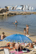 Bathers on beach of Scalettino near the wreck of Costa Concordia, Isola Del Giglio, Italy - 07 Jul 2012