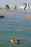 Bathers on beach of Scalettino near the wreck of Costa Concordia, Isola Del Giglio, Italy - 07 Jul 2012