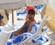 Twilight'' star Kellan Lutz spends a day on the beach with super thin girlfriend Sharni Vinson. The two played in the waves and relaxed in a small area surrounded by umbrellas. Kellan took time to pose for a photo with a young fan before heading off the b