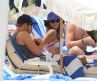 Twilight'' star Kellan Lutz spends a day on the beach with super thin girlfriend Sharni Vinson. The two played in the waves and relaxed in a small area surrounded by umbrellas. Kellan took time to pose for a photo with a young fan before heading off the b