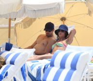 Twilight'' star Kellan Lutz spends a day on the beach with super thin girlfriend Sharni Vinson. The two played in the waves and relaxed in a small area surrounded by umbrellas. Kellan took time to pose for a photo with a young fan before heading off the b