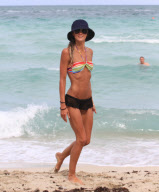 Twilight'' star Kellan Lutz spends a day on the beach with super thin girlfriend Sharni Vinson. The two played in the waves and relaxed in a small area surrounded by umbrellas. Kellan took time to pose for a photo with a young fan before heading off the b