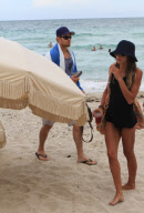 Twilight'' star Kellan Lutz spends a day on the beach with super thin girlfriend Sharni Vinson. The two played in the waves and relaxed in a small area surrounded by umbrellas. Kellan took time to pose for a photo with a young fan before heading off the b