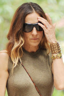 Actress Sarah Jessica Parker sitting on the stairs having a chat with a friend
