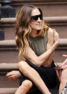 Actress Sarah Jessica Parker sitting on the stairs having a chat with a friend
