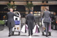 Savoy hotel doormen taking clothing and products to be used at the EE BAFTA awards, to the styling suites, London, Britain-8th Feb 2012