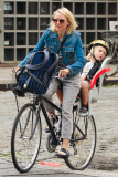 Naomi Watts is all smiles as she rides her bike to school